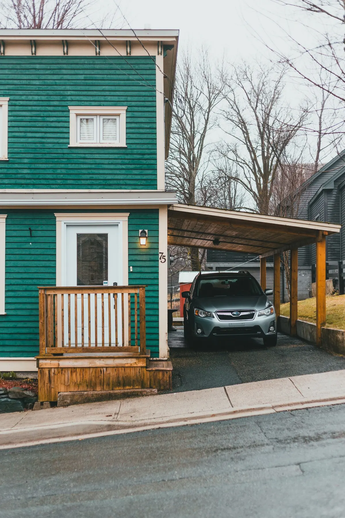 Car parked under a carport attached to a house