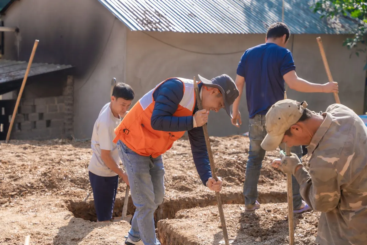 Workers digging a foundation footing trench by hand