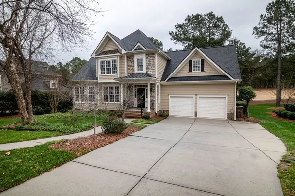 A curved concrete driveway in front of a two-car garage