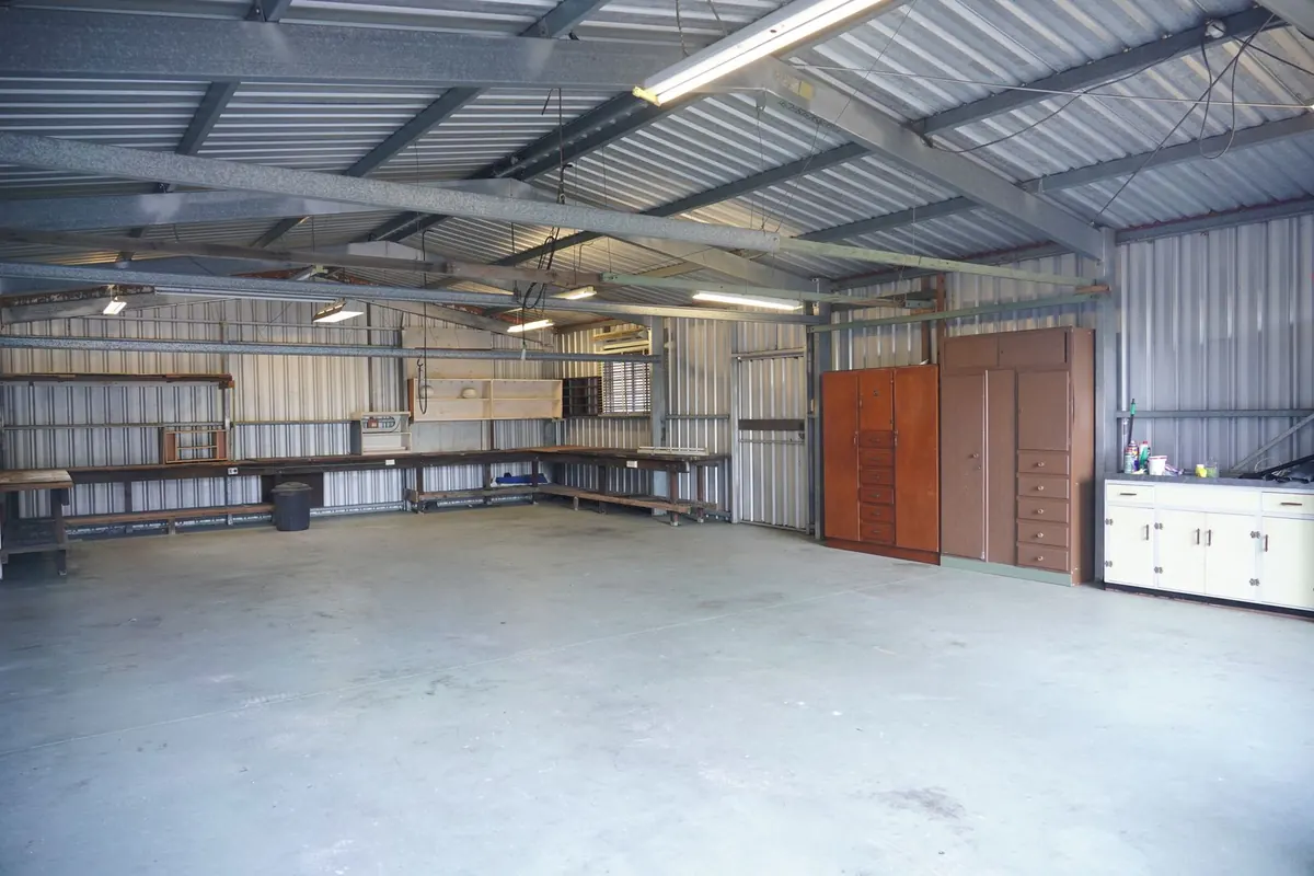 Metal building interior with workbenches standing on a concrete slab floor