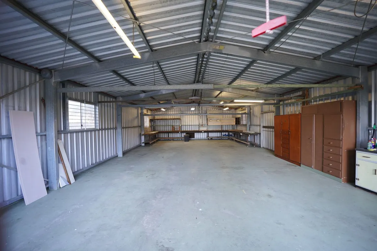 Inside an empty metal shop building with a smooth concrete floor