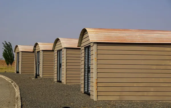 A row of storage sheds on a gravel base