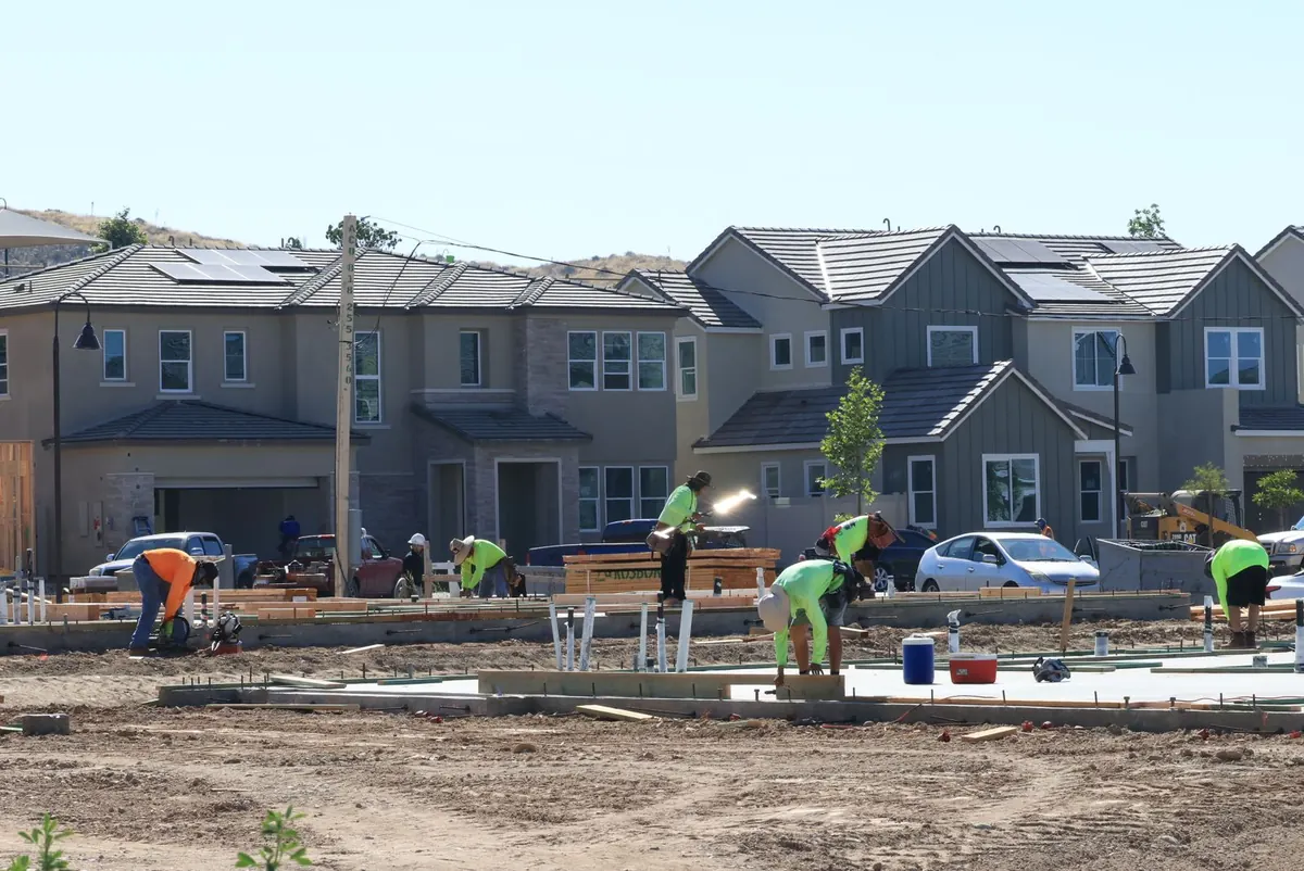 Crews working on slab foundations on lots in a new housing development